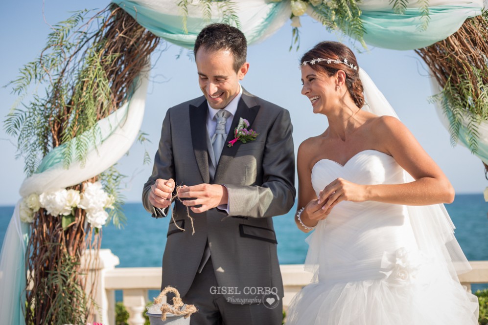 35 novios felices poniendo anillos en boda con vistas al mar